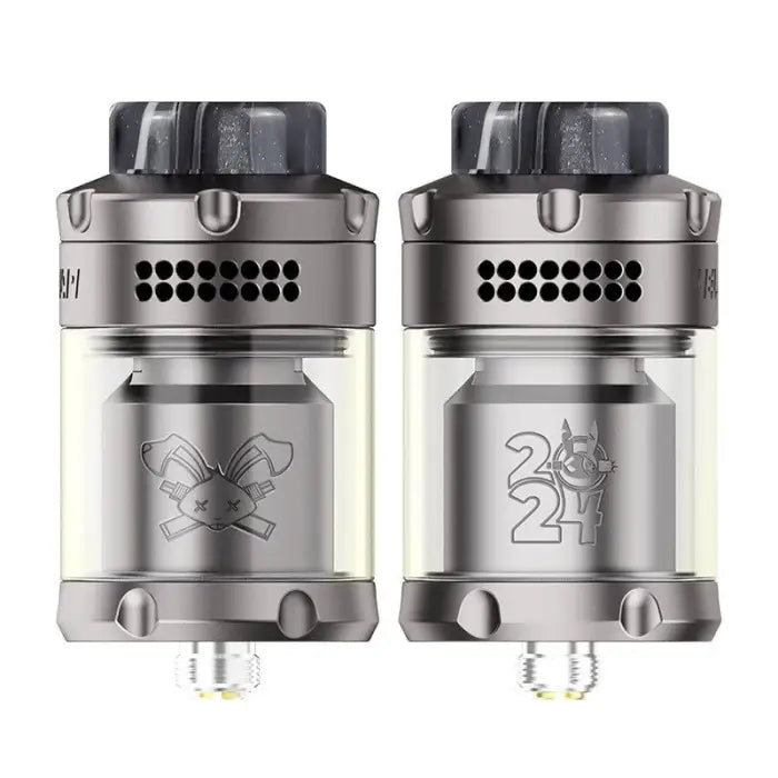 Two identical vaping atomizers or tanks with different engraved designs on their bodies.