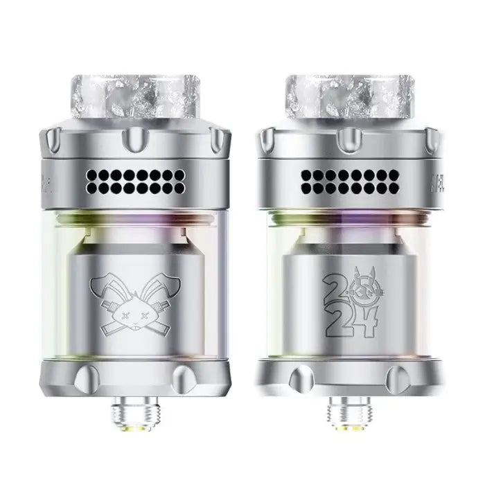 Two cylindrical metal vaping tanks or atomizers with engraved designs and colorful accents.