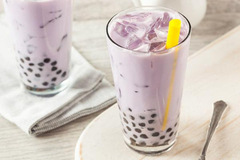 Glass of purple bubble tea with tapioca pearls, inspired by Mamasan Purple Cheesecake.